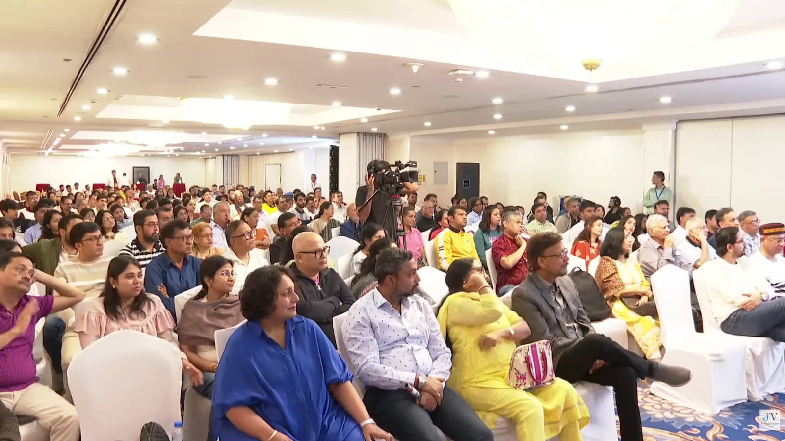 A large seated audience at a conference