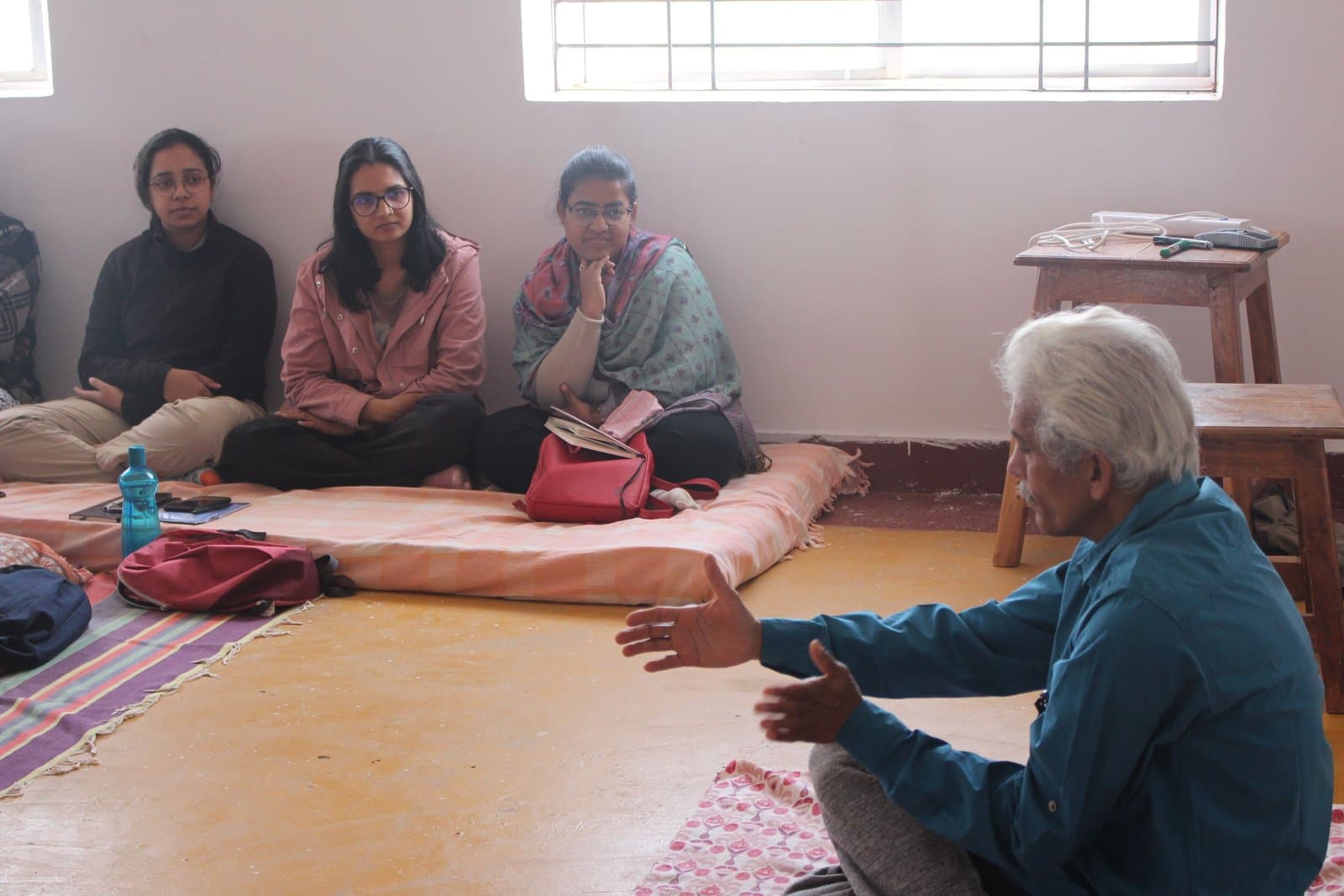 An elder in dialogue with a small group indoors