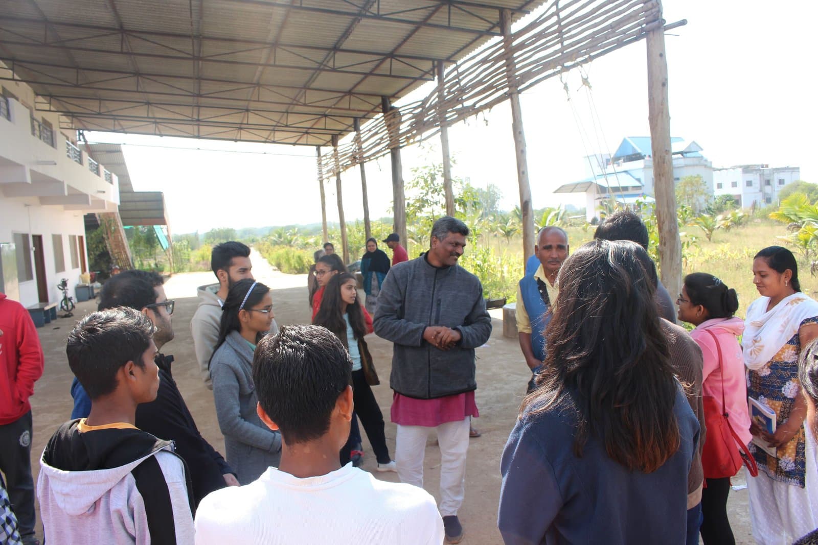 A facilitator in conversation with a group gathered outdoors